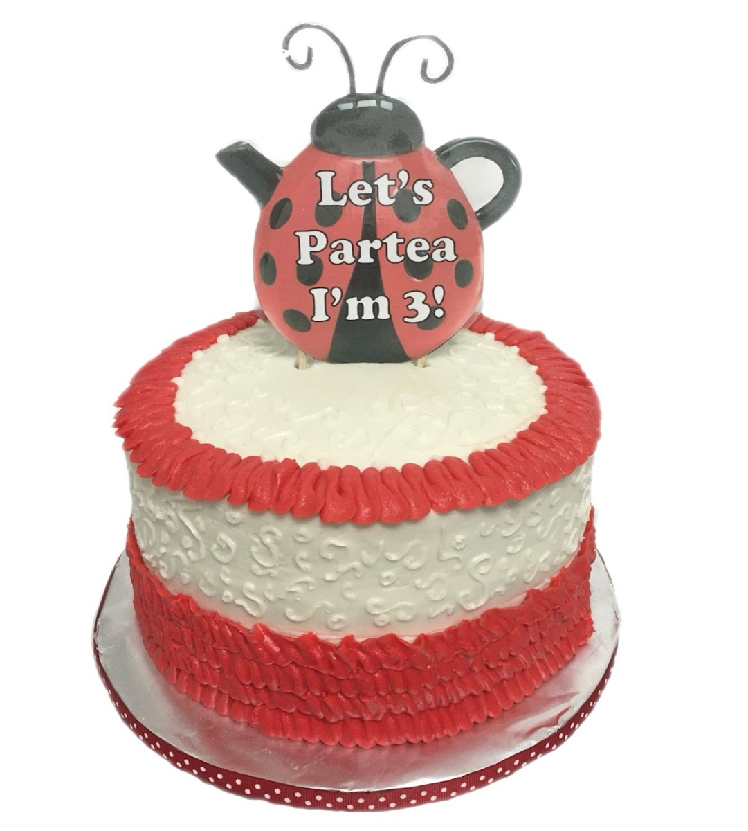 Red-and-white tiered birthday cake with a ladybug teapot topper