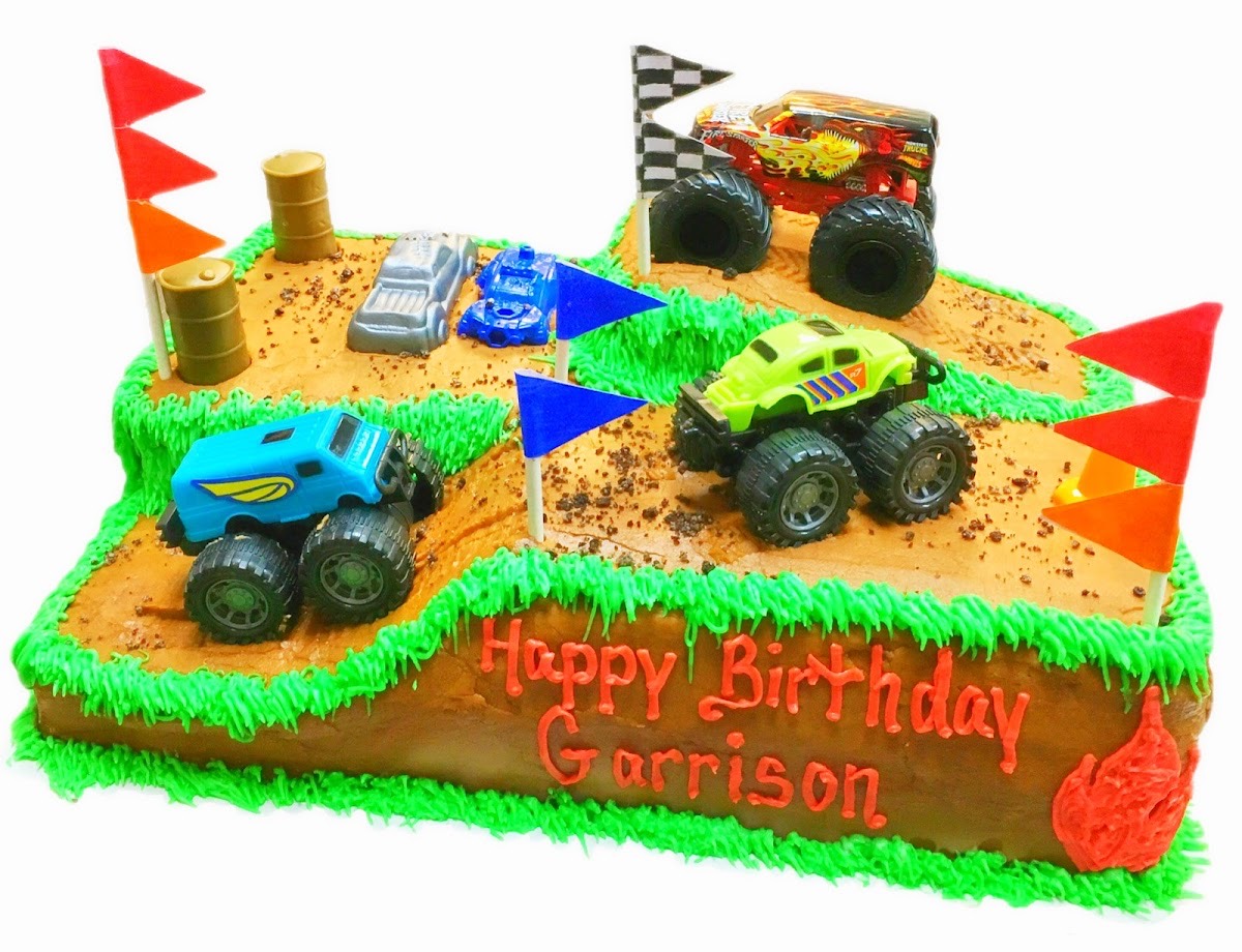 Monster-truck themed birthday cake with toy trucks on top